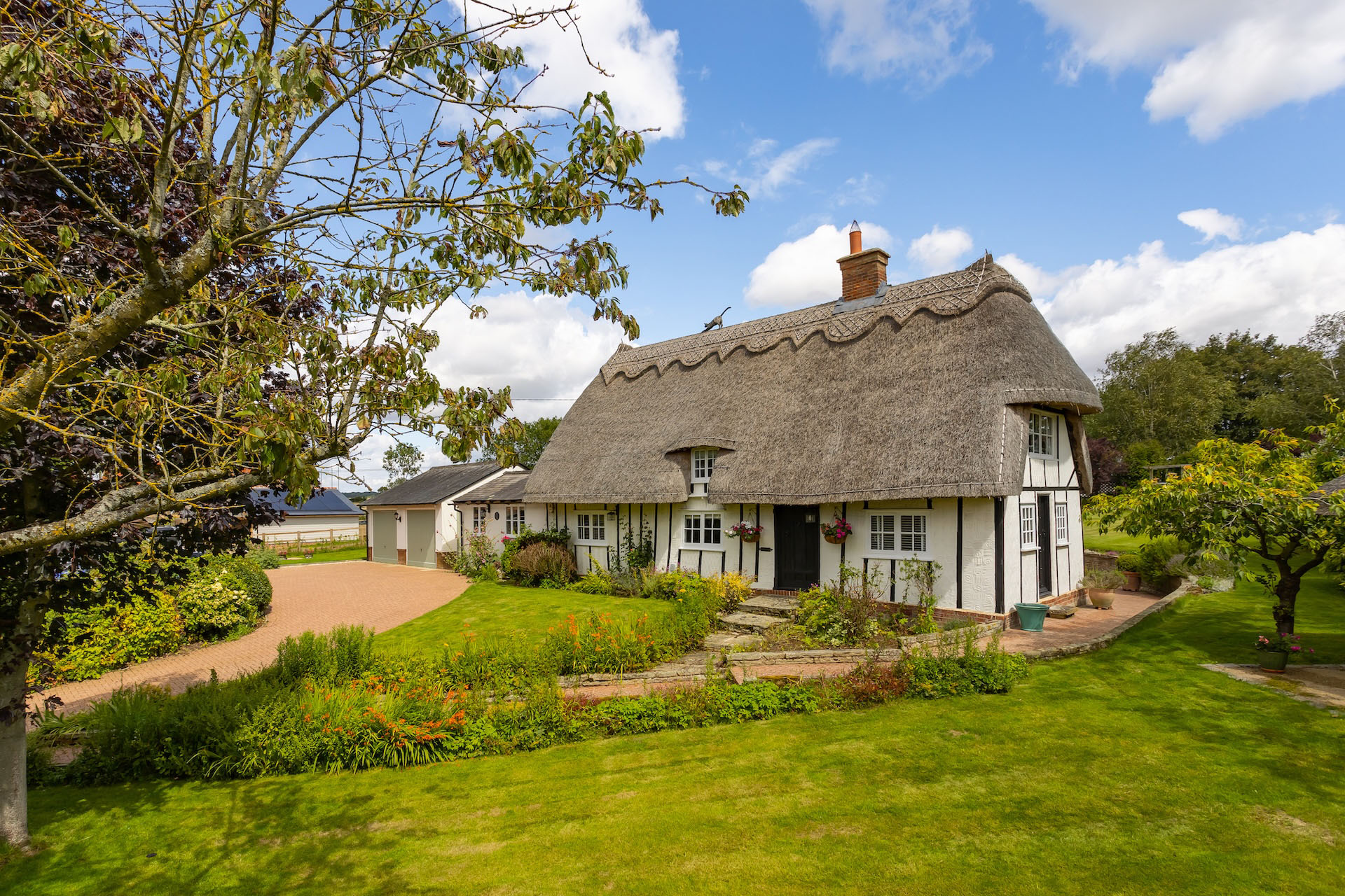 Thatched cottage surrounded by a landscaped garden