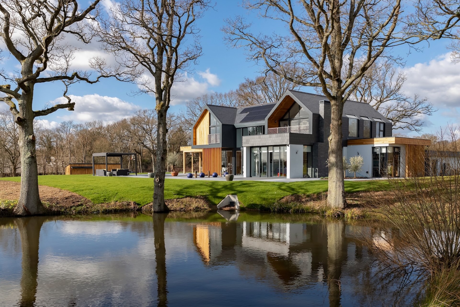 Contemporary lakeside house framed by trees