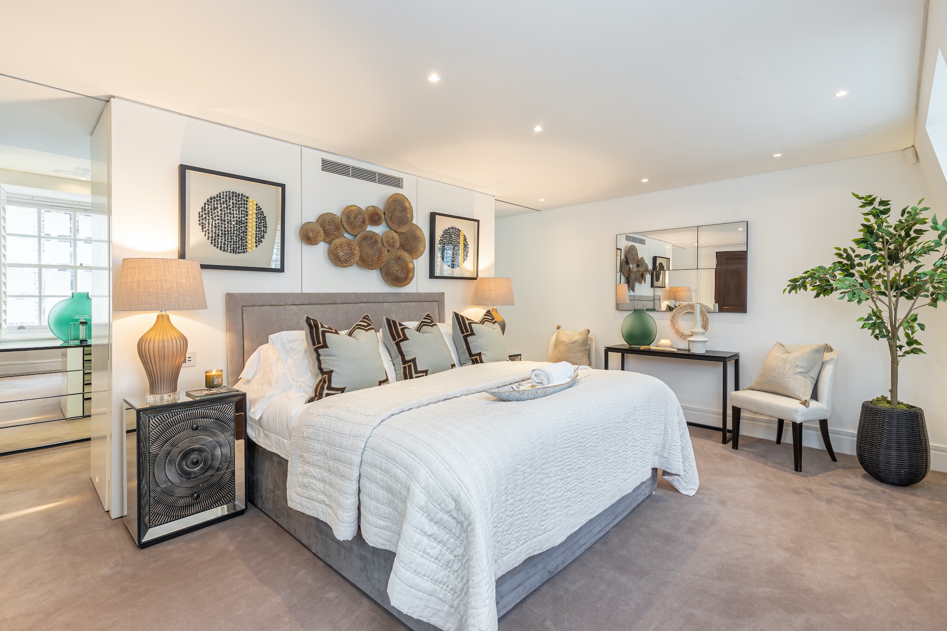 Bright bedroom with artwork and upholstered seating