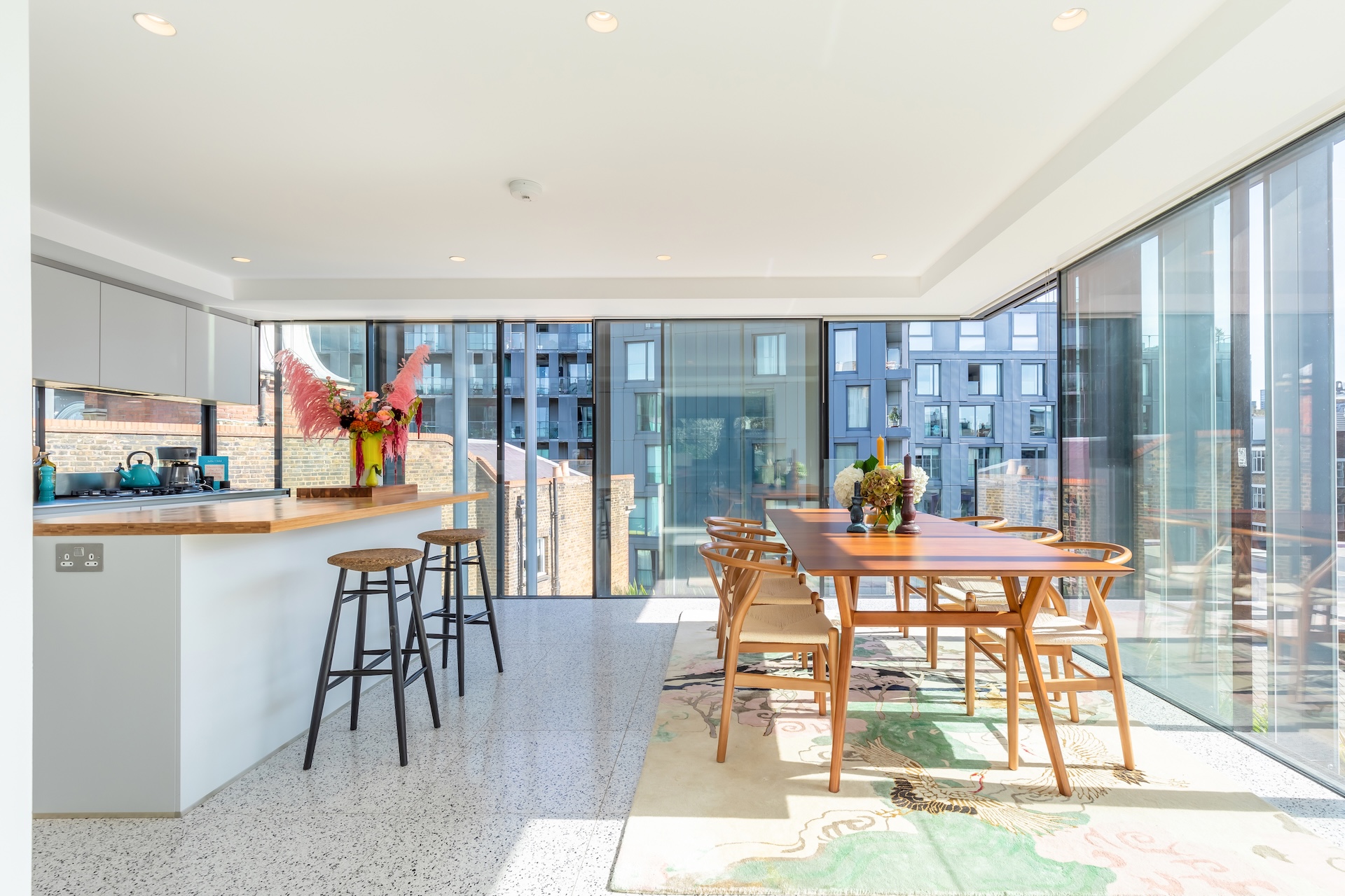 Light-filled kitchen and dining room with glass walls